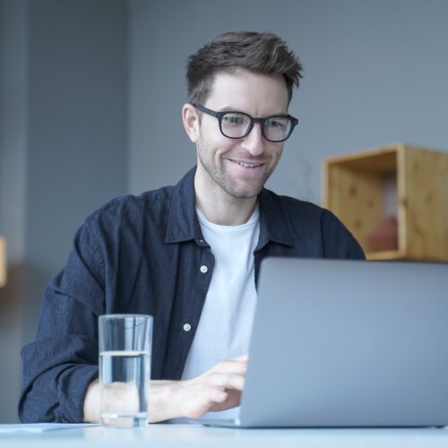 young-smiling-businessman-european-financial-consultant-working-remotely-online-from-home-office.jpg